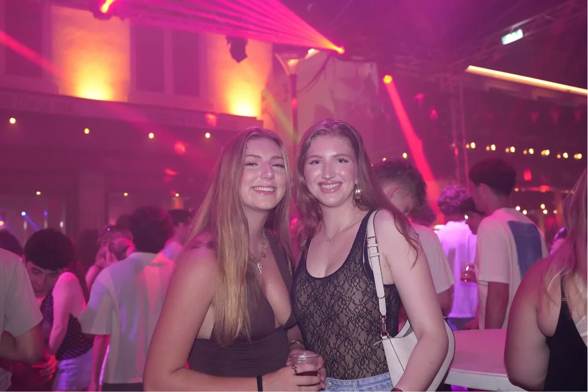 Drukte op de dansvloer in roze licht